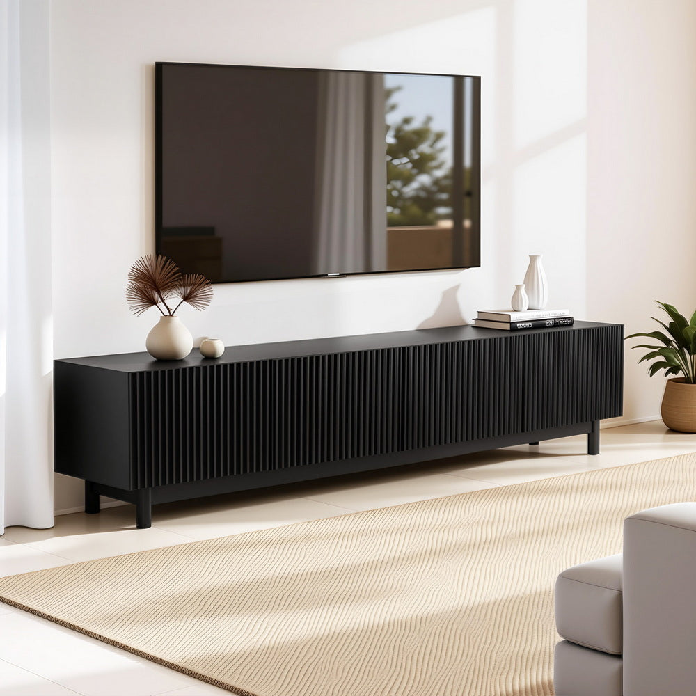 Modern living room with a black TV stand and mounted television.